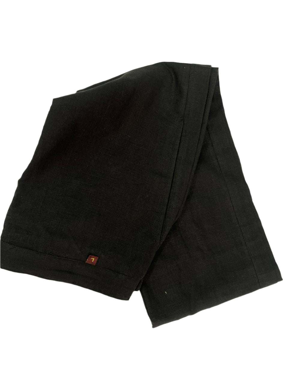 Black fabric with a small red tag on a light beige background