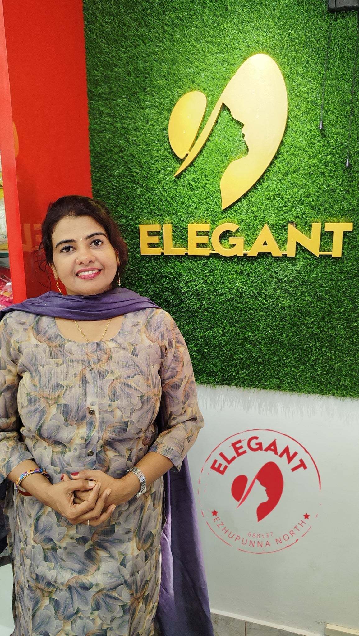 Woman wearing a shimmer fabric churidar set posing in front of an Elegant style sanctuary sign