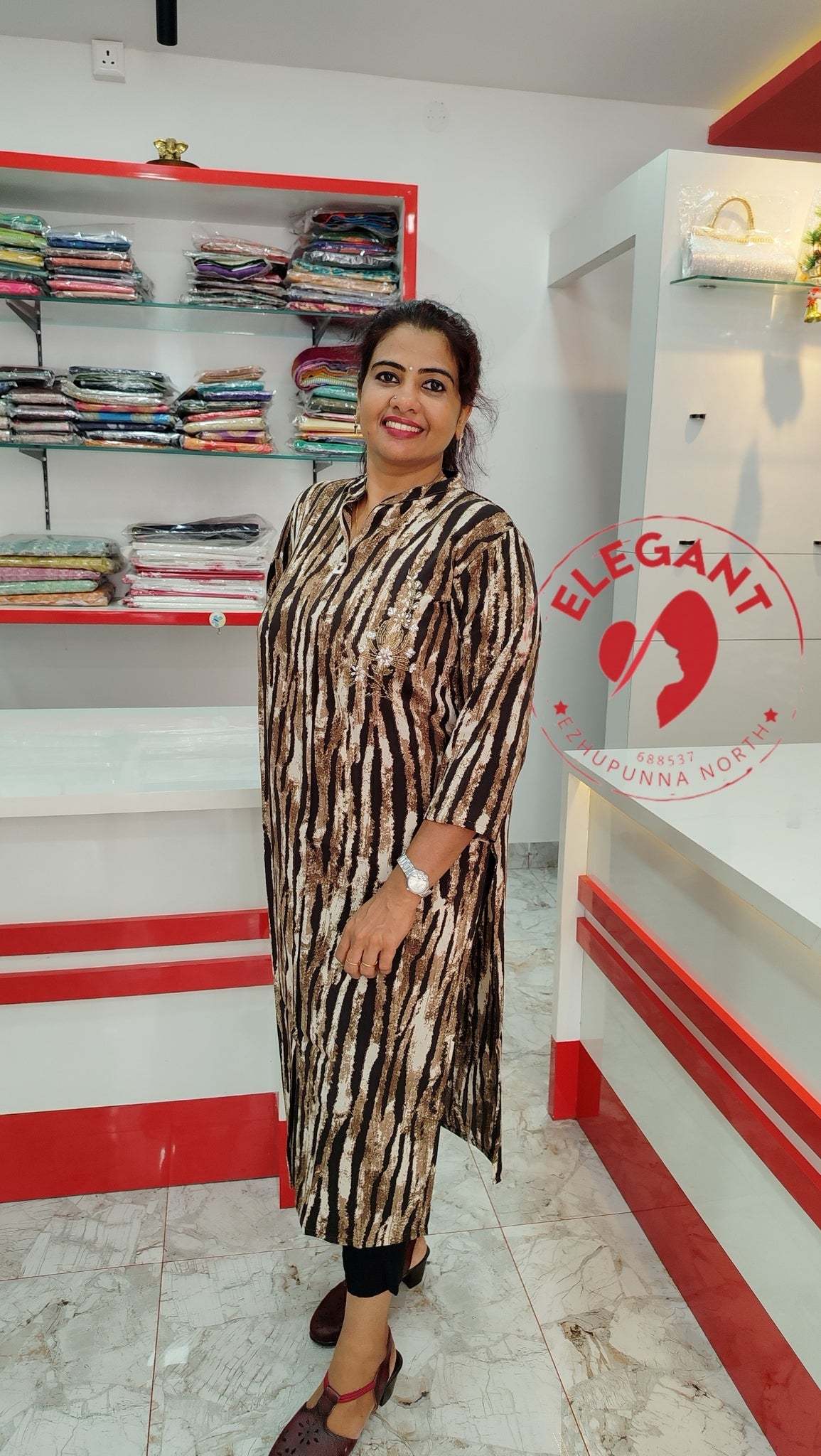 Woman wearing an elegant imported crepe top with striped pattern standing in a clothing store.