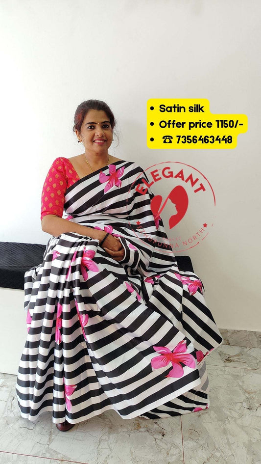 Woman wearing black and white striped satin silk saree with pink floral prints sitting indoors