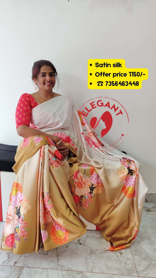 Woman wearing a floral satin silk saree with pink blouse sitting indoors showcasing elegant drape