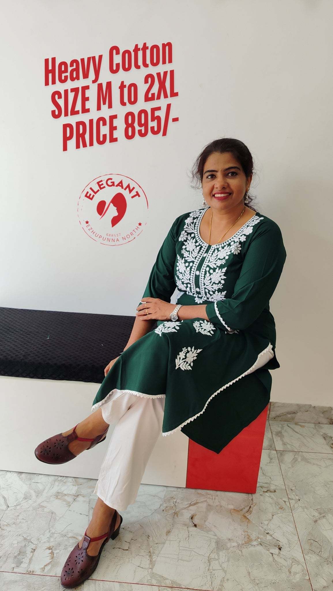 Woman wearing green heavy cotton top with white embroidery sitting on a bench, advertised as available in sizes M to 2XL for 895/-