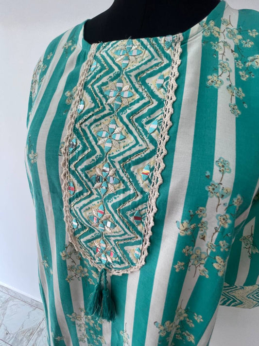 Teal and white striped top with decorative patterns on a mannequin against a white background