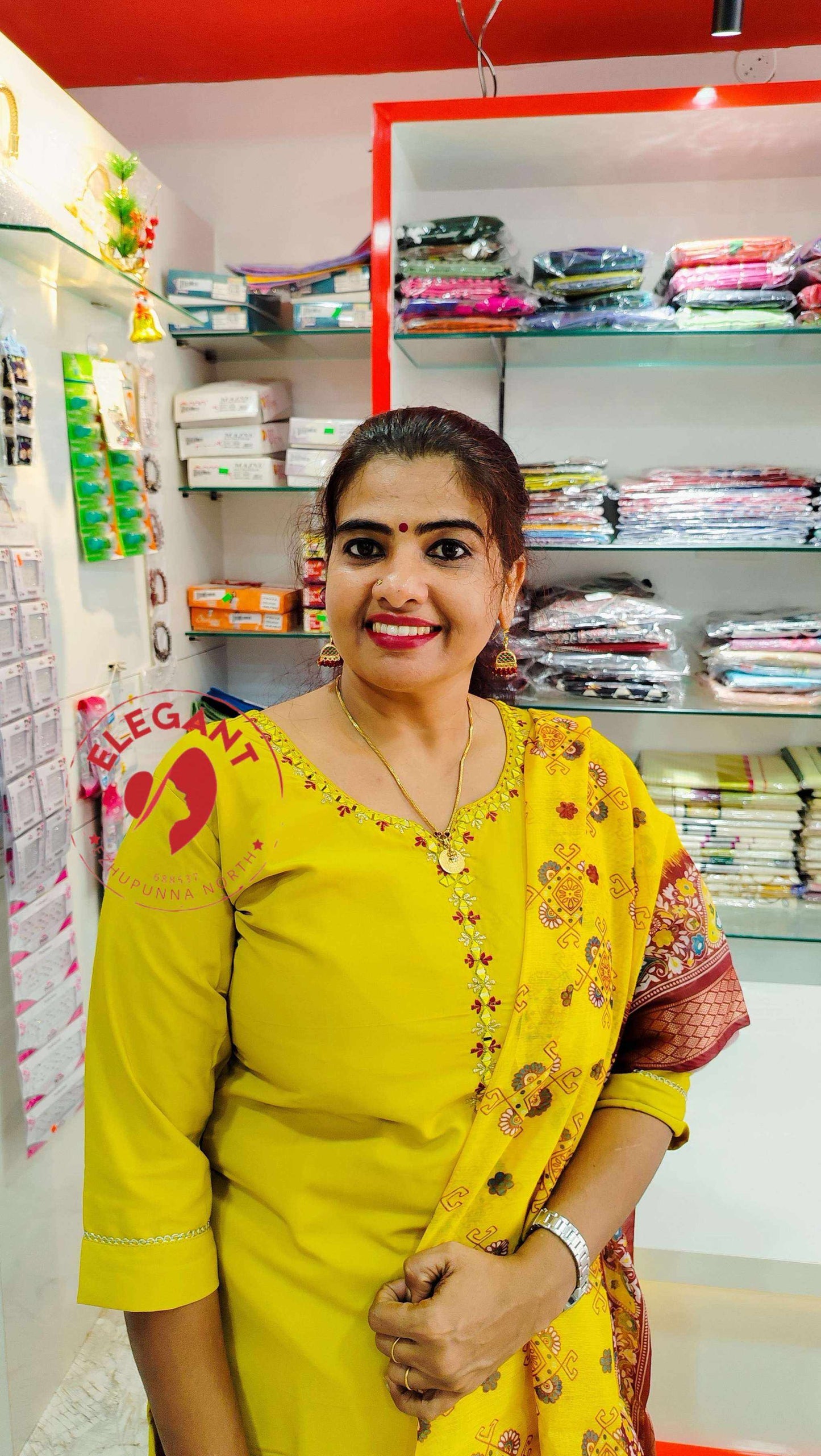 Woman in yellow Roman silk churidar standing in fabric store with shelves of folded textiles