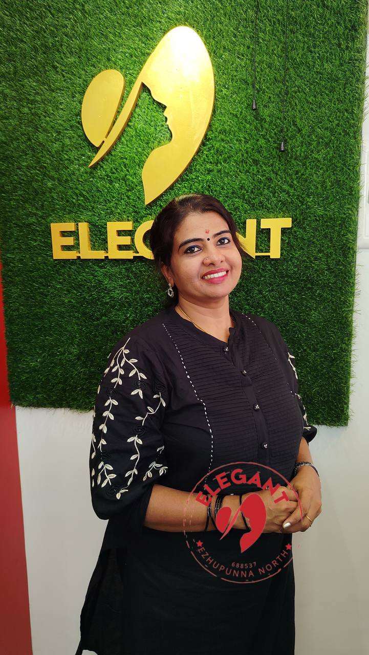 Woman wearing a black cotton Kurthi Set with white embroidery standing in front of a green wall with Elegant logo