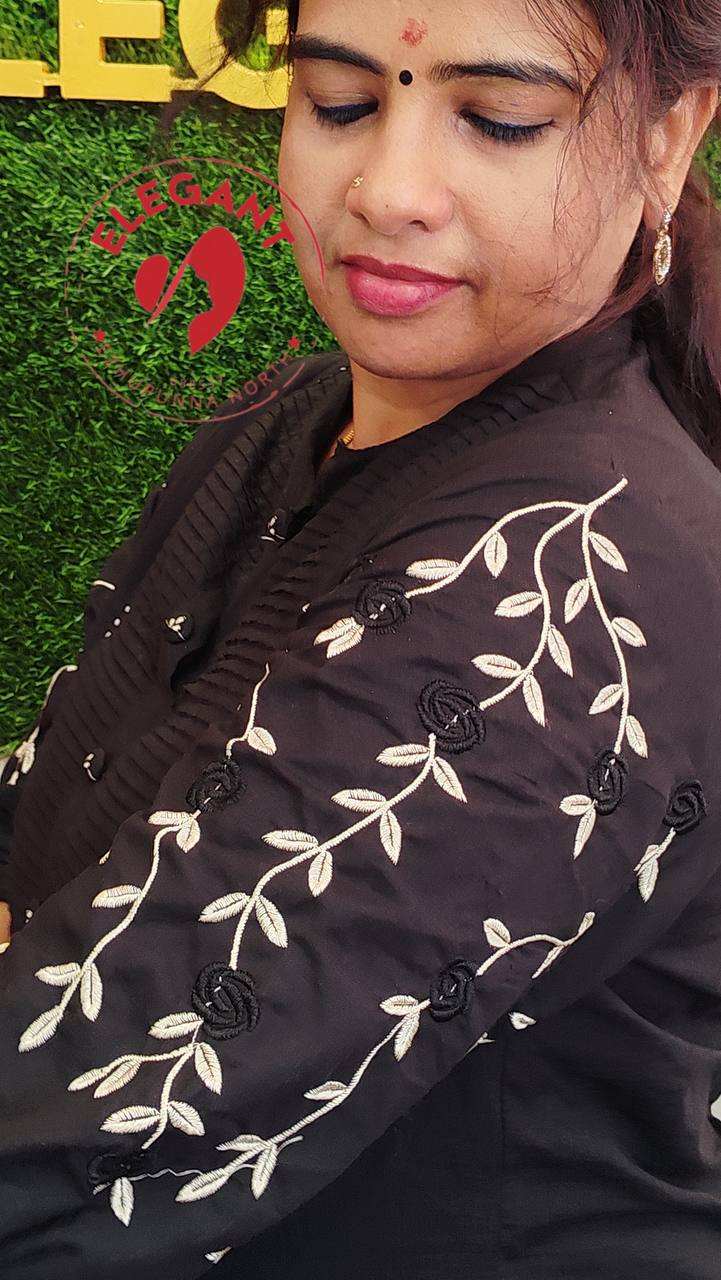 Woman wearing black cotton Kurthi Set with white floral embroidery on sleeve, showcasing elegant and comfortable traditional attire.