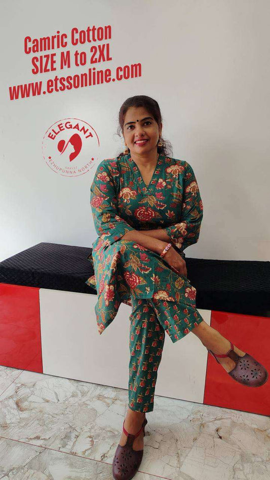 Woman wearing green floral camric cotton Kurthi Set sitting on a bench, showcasing comfortable and stylish ethnic wear
