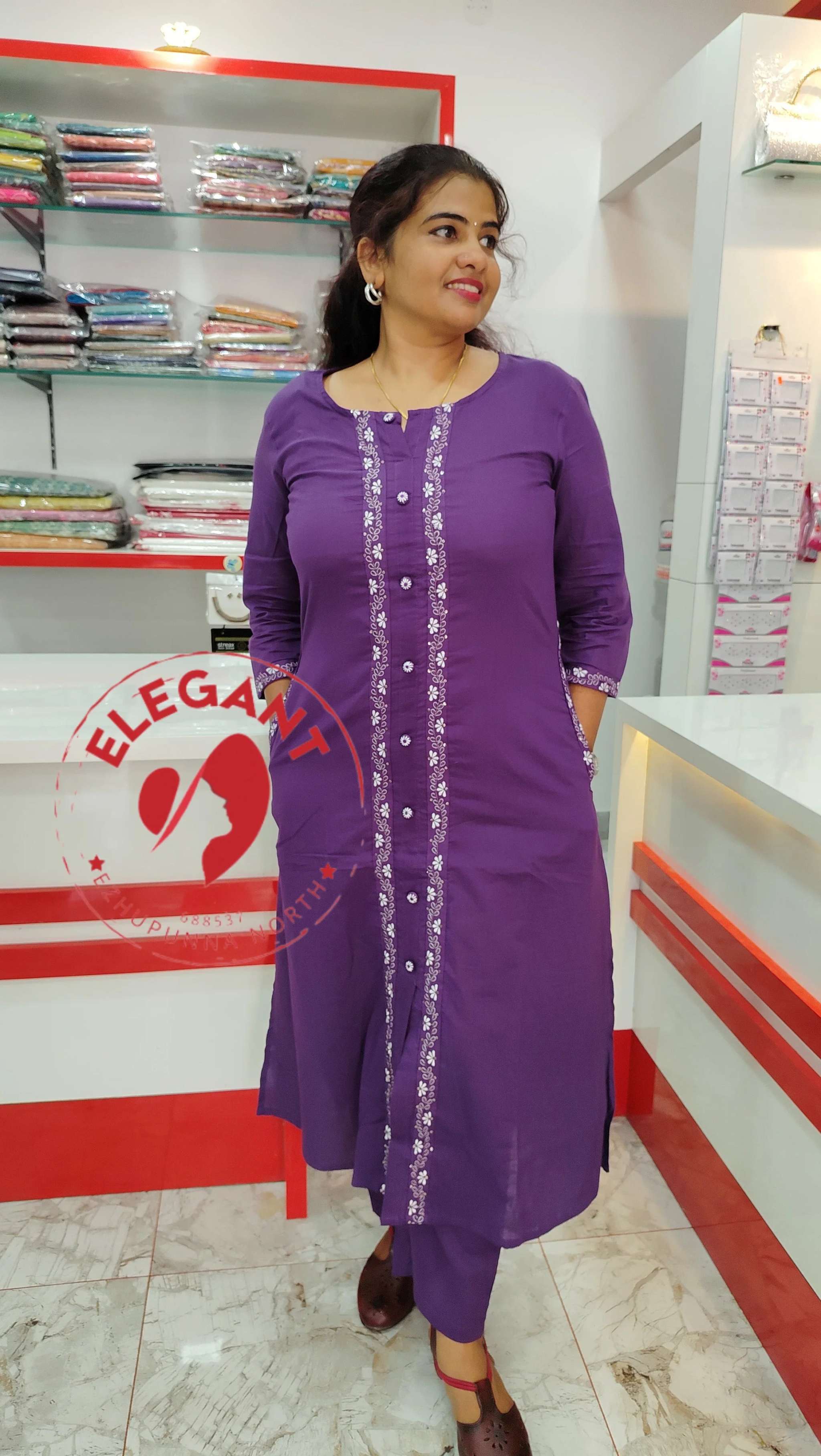 Woman wearing a purple cotton Kurthi Set with decorative front panel standing in a clothing store.