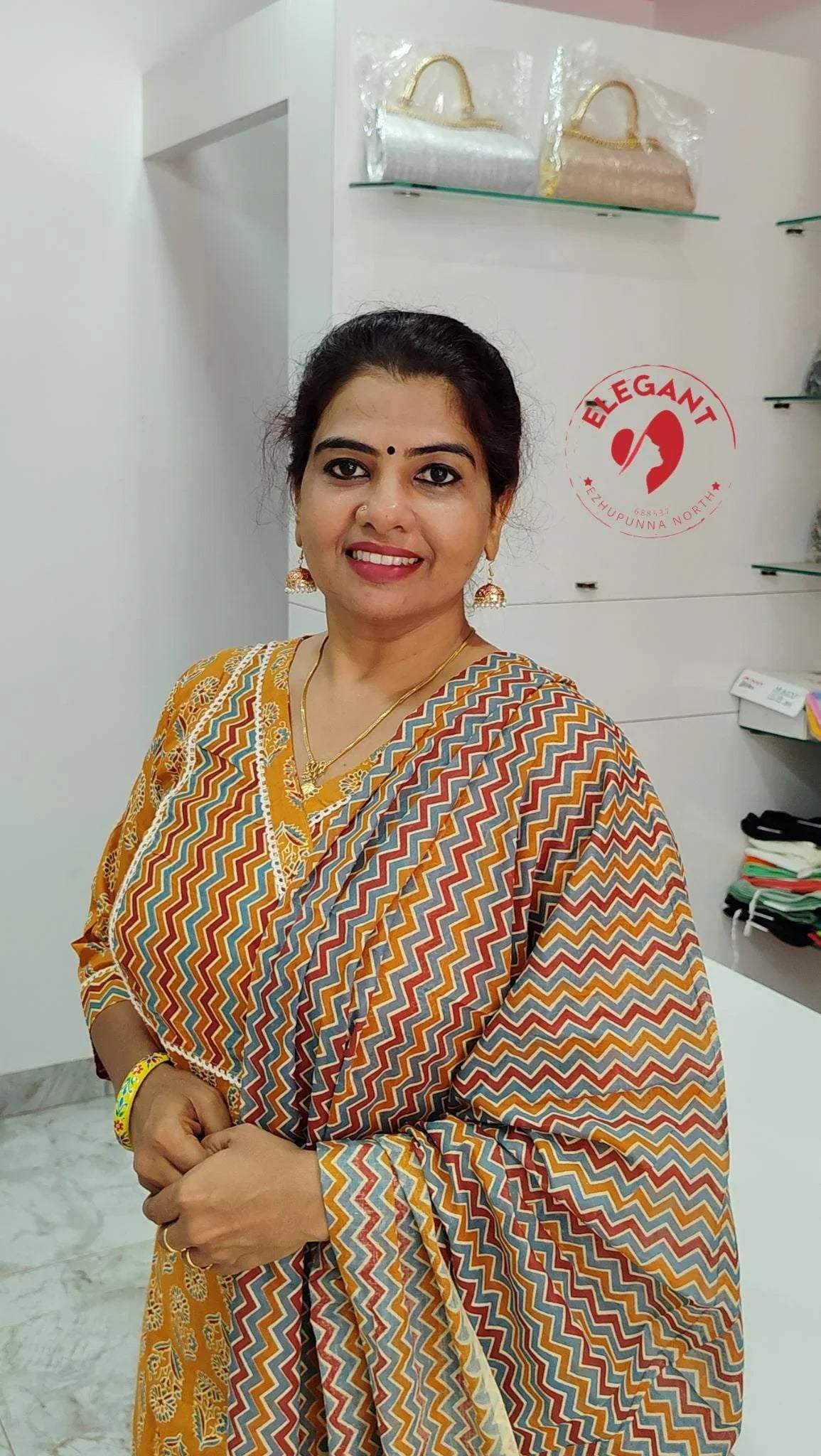 Woman wearing a colorful zigzag patterned churidar set in a boutique setting