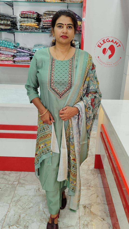 Woman wearing elegant Roman silk churidar with intricate embroidery and patterned dupatta standing in fabric store