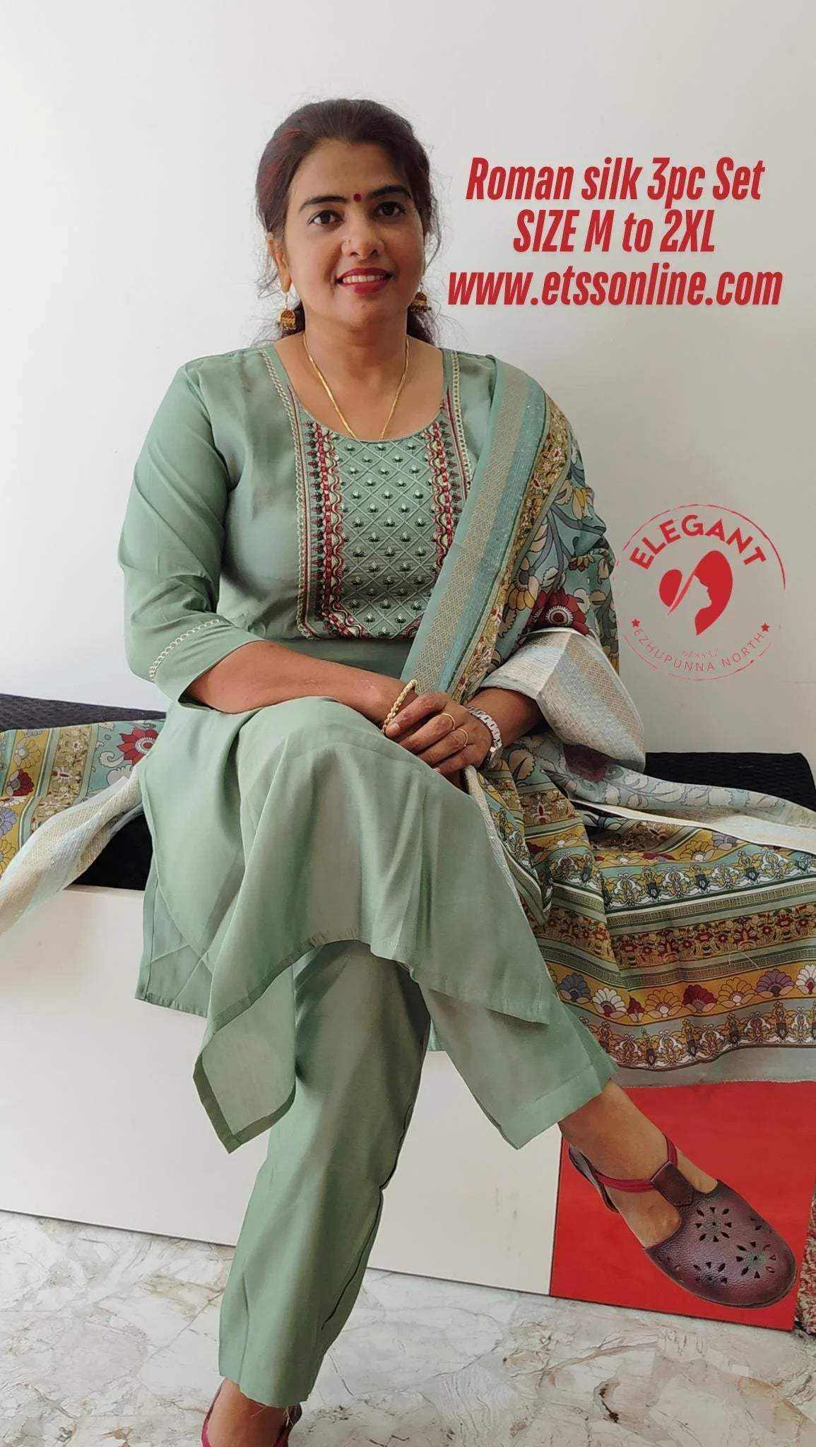Woman wearing elegant light green Roman silk churidar set with detailed embroidery and matching dupatta seated indoors