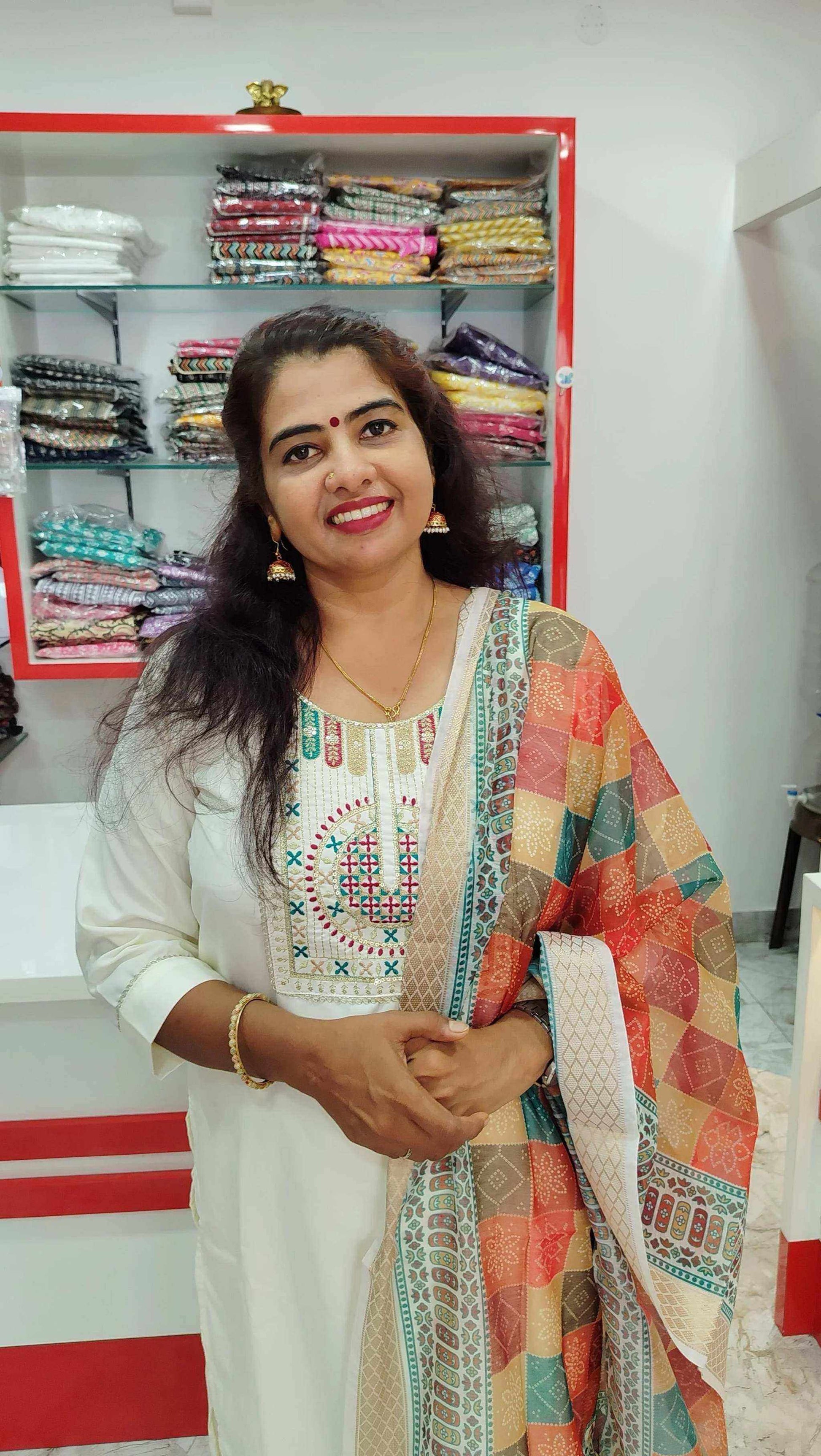 Woman wearing elegant Roman Silk Churidar with colorful patterned dupatta in fabric store