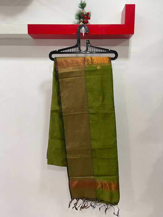 Green and brown saree with a hanger on a white wall