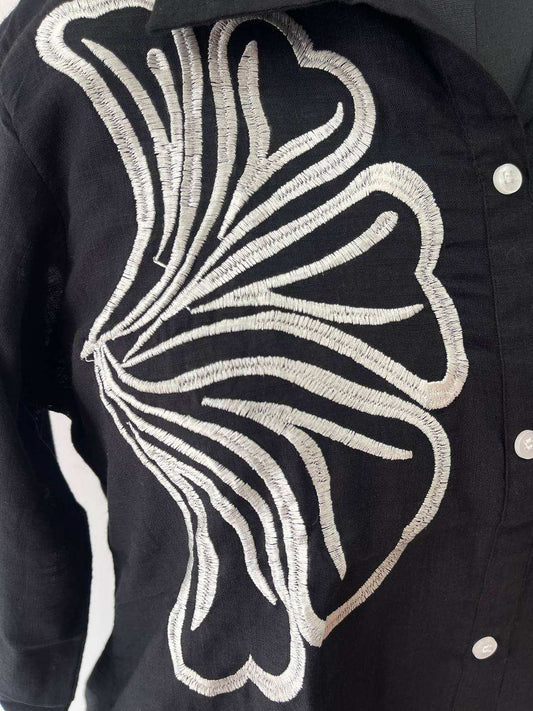 Black jacket with white embroidered design on a dark background